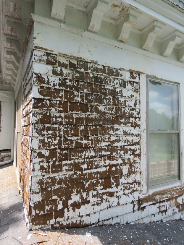 Faded, cracked siding panels on an older home